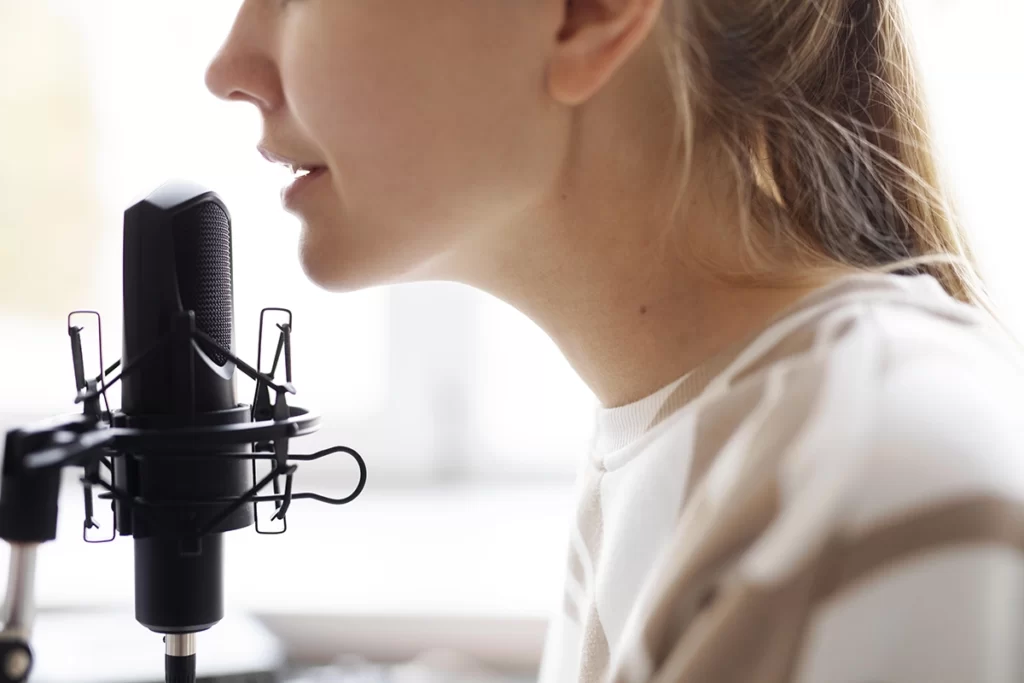 Une femme enregistre sa voix pour un message vocal